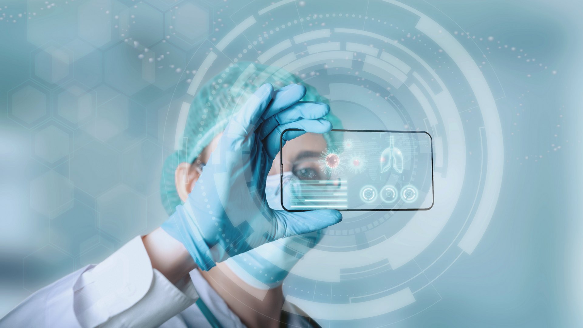 Digitalisierung Krankenhaus: Ärztin mit persönlicher Schutzausrüstung schaut auf transparentes Smartphone mit Medizindaten