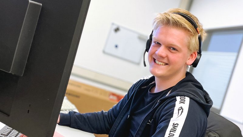 BEWATEC Support-Mitarbeiter lächelnd mit Headset am Rechner